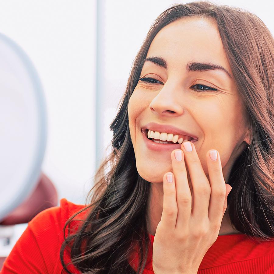 Woman admiring her new dental implants and smile in Ventura